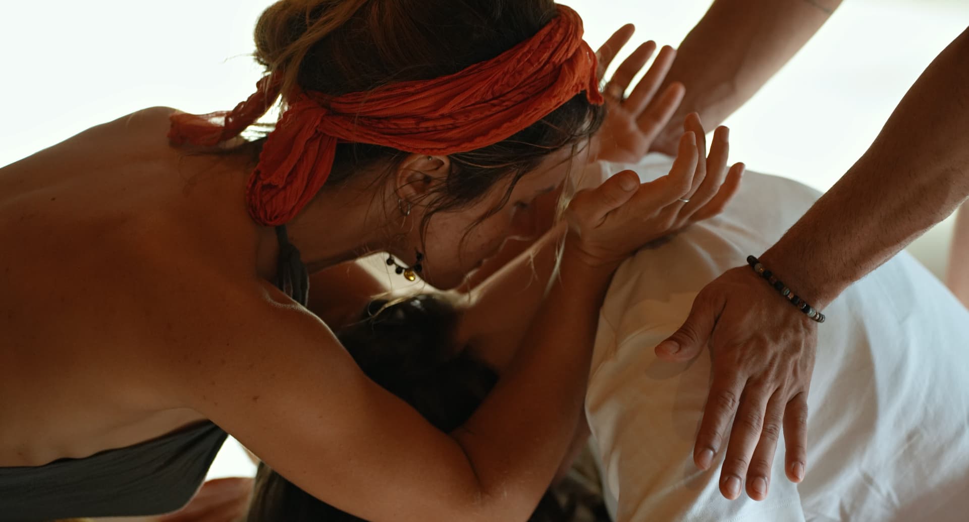 Hands resting gently on a participant lying down during a bodywork session
